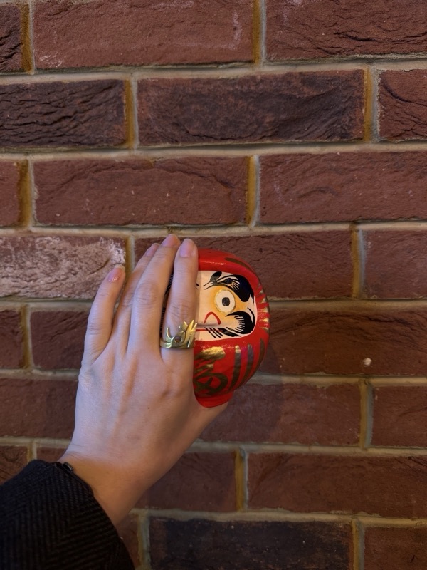 Daruma doll against the brick wall