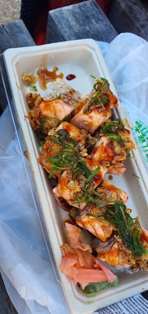 Seared salmon rolls in a takeaway tray